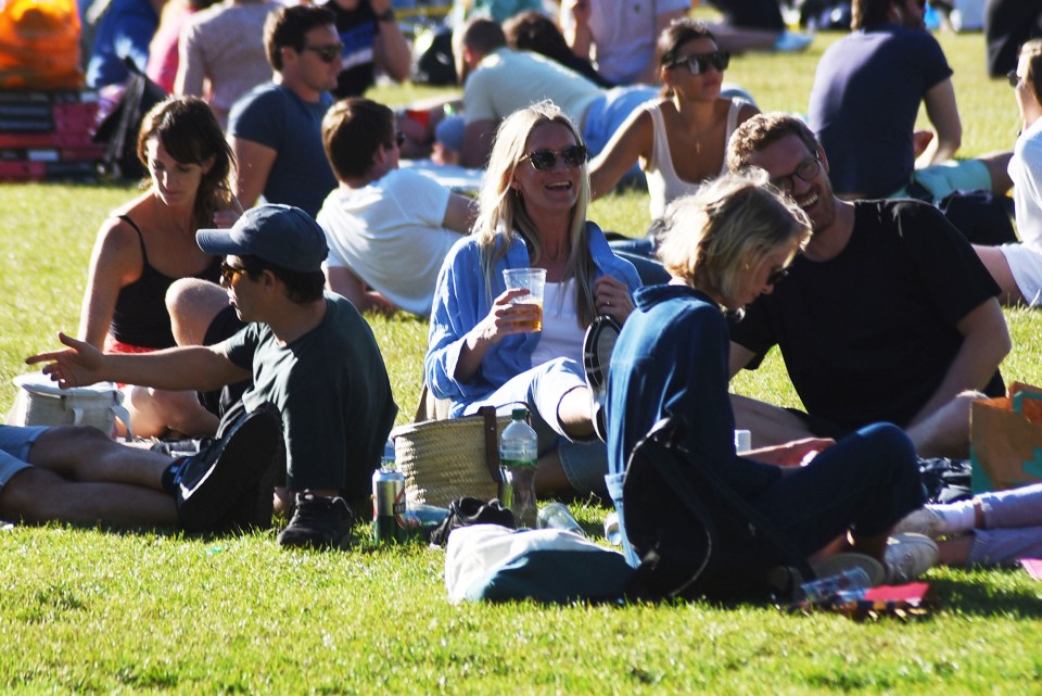 People out drinking on Wandsworth Common with takeaway beers