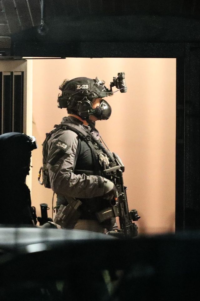 An armed officer stands guard at the apartment block