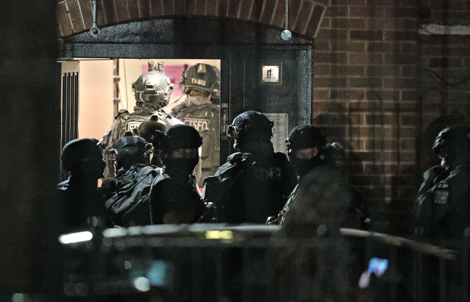 Armed police officers arrive at a block of flats off Basingstoke Rd 