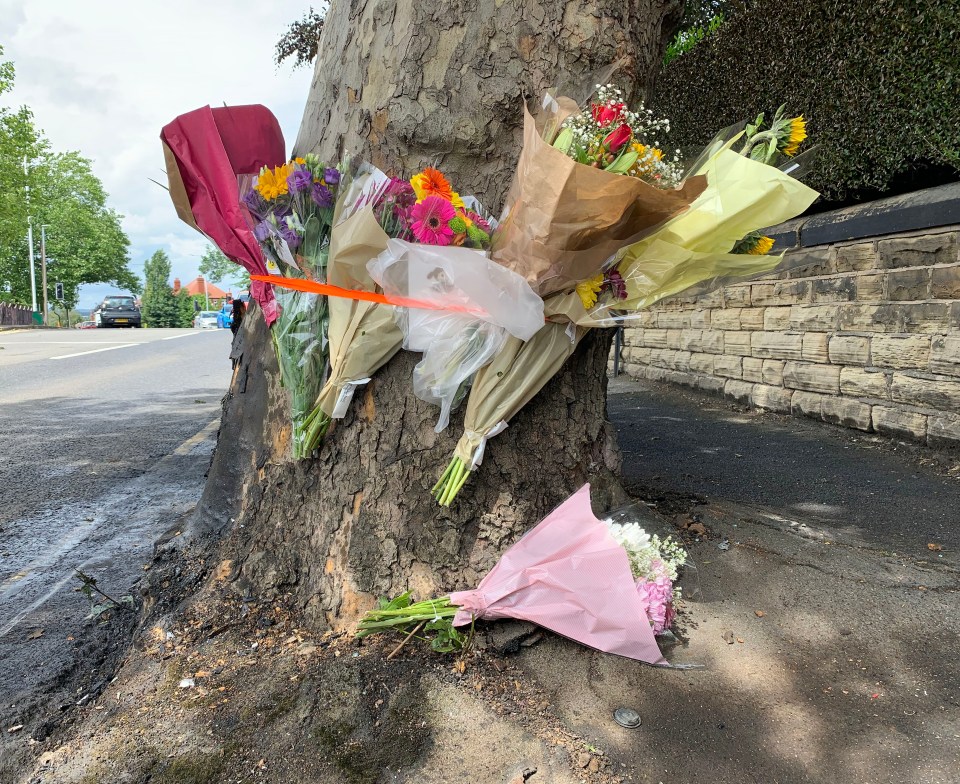  Floral tributes near the tree where the couple died