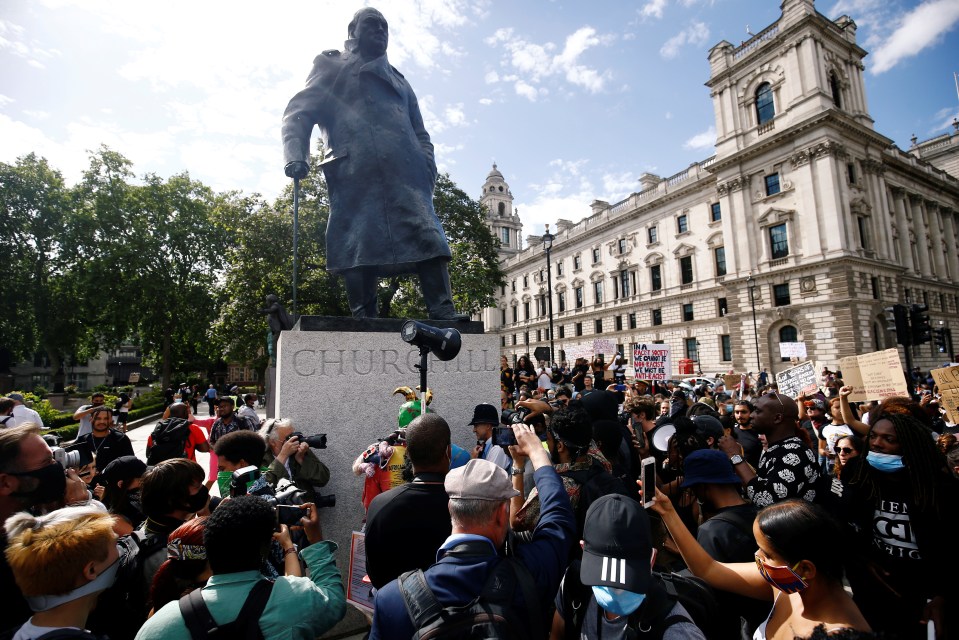 People gather on Parliament Square next to a statue of Winston Churchill during a Black Lives Matter protest with a row over whether statues should be taken down igniting