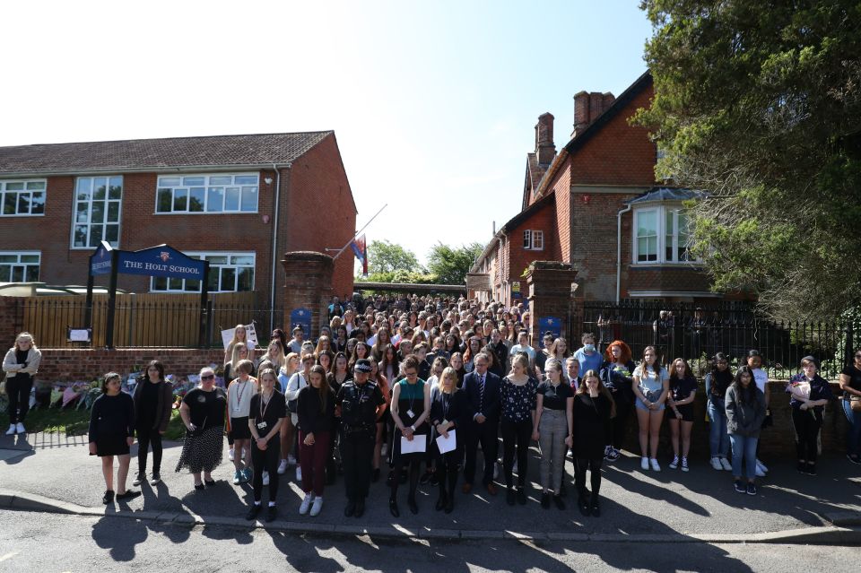 Colleagues and pupils of teacher James Furlong take part in a period of silence at the Holt School