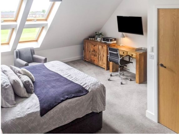 One of the huge bedrooms is also big enough for an armchair and a desk too