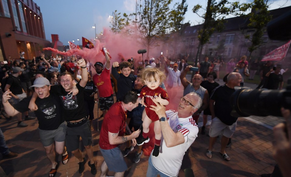 Ecstatic Liverpool FC supporters celebrate outside Anfield