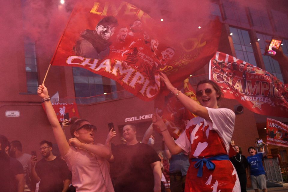 Liverpool fans celebrate after finally getting their hands on the Premier League trophy