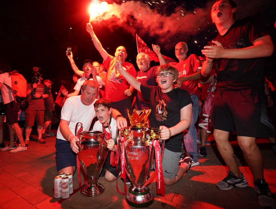 Liverpool supporters with replica Premier League and Champions League trophies