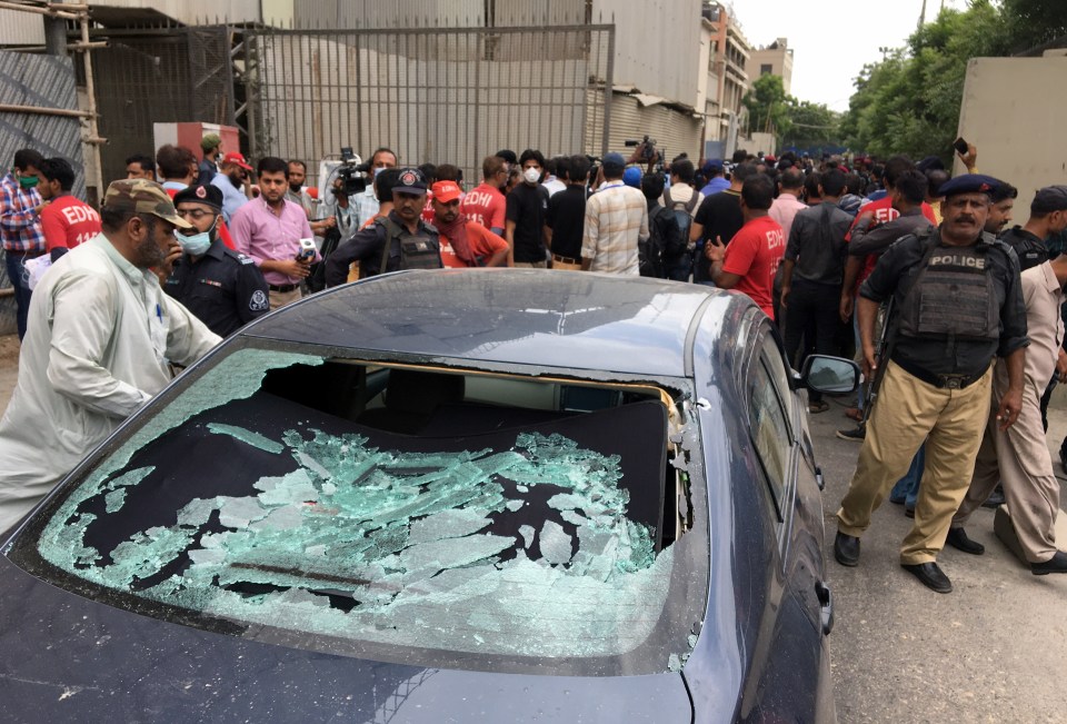 Crowds gather round a car outside the stock exchange