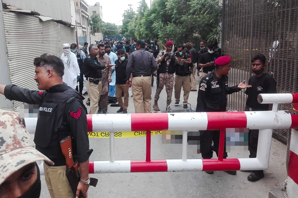 Policemen secure an area around a body outside the Pakistan Stock Exchange