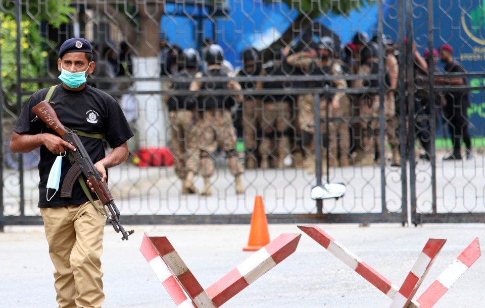 Pakistani security officials inspect the scene of an attack by banned militants outfit Baloch Liberation Army