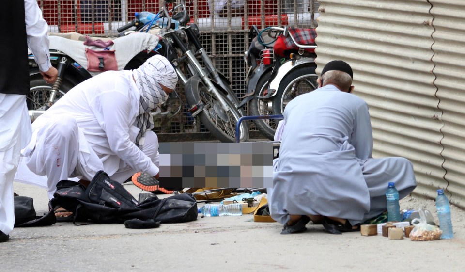 Pakistani security officials inspect weapons and ammunition recovered at the scene of the attack 