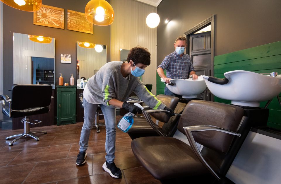 Maria Demetriou-Clamp and Robin Dignall disinfect chairs at their hair salon 'Hair @ 1RD'