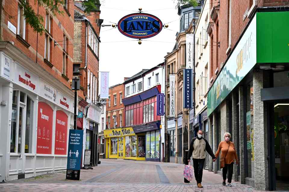 Masked couple walk through deserted shops in the city