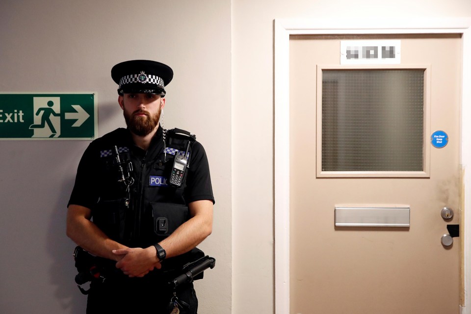 Police officers standing guard outside the flat they raided overnight