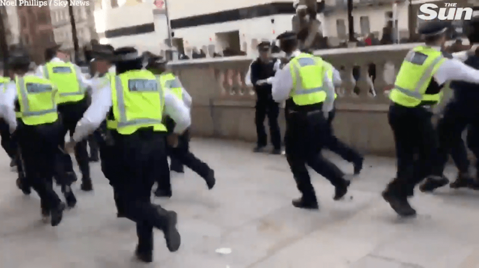 Footage shows a mob surrounding the officers, forcing them to flee