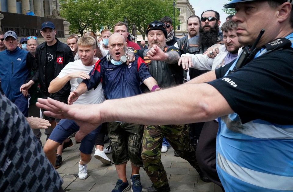 A police officer tried to hold the two groups apart as they met yesterday afternoon in Bolton