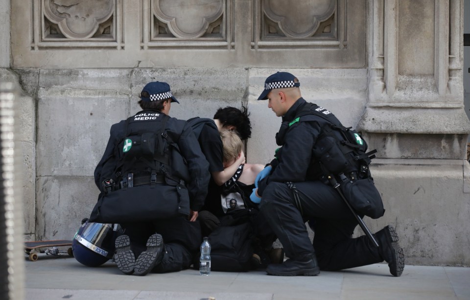 Police treat a Black Lives Matter protester injured after they clashed with the counter groups