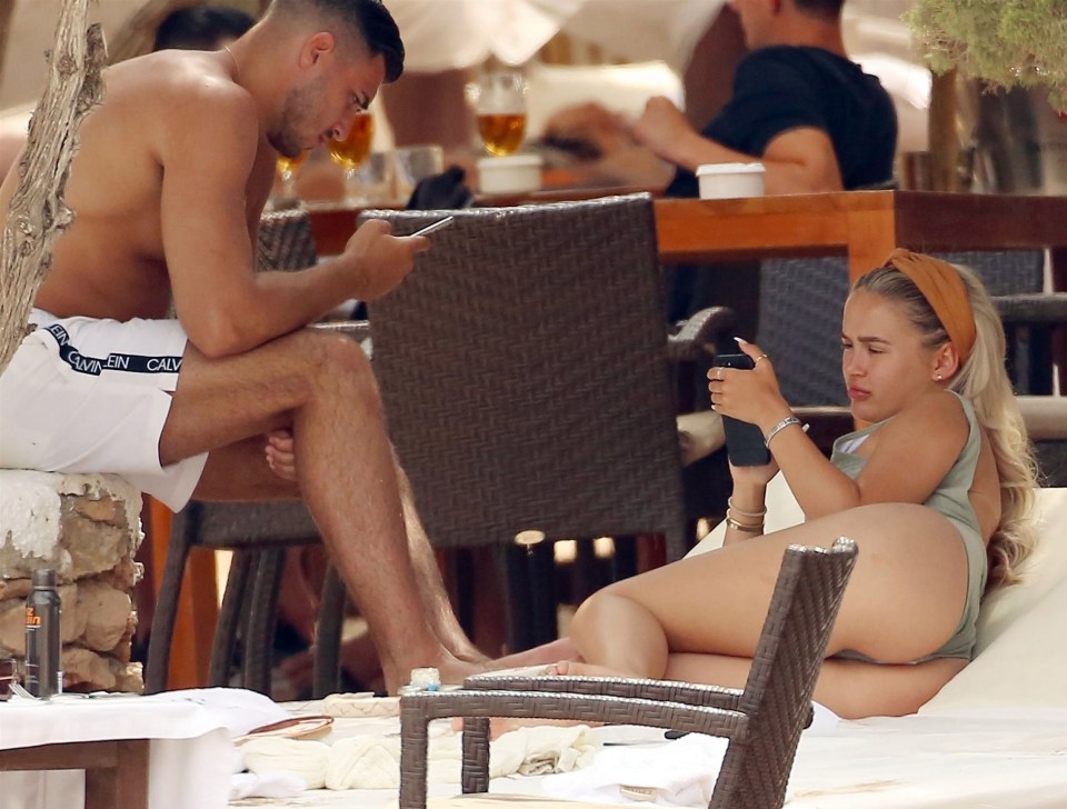 They each had messages to catch up on during the sun-soaked holiday