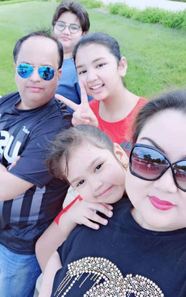 Zumret, now living in the United States with her husband and three kids, smiles with her family in a selfie