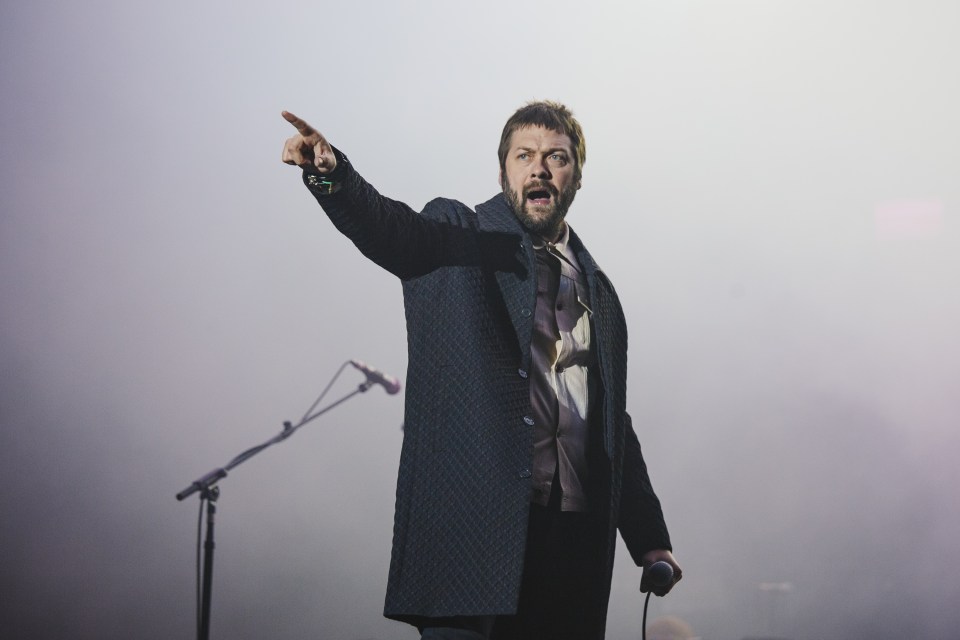 Tom performing on stage with Kasabian at Leeds Festival in 2017