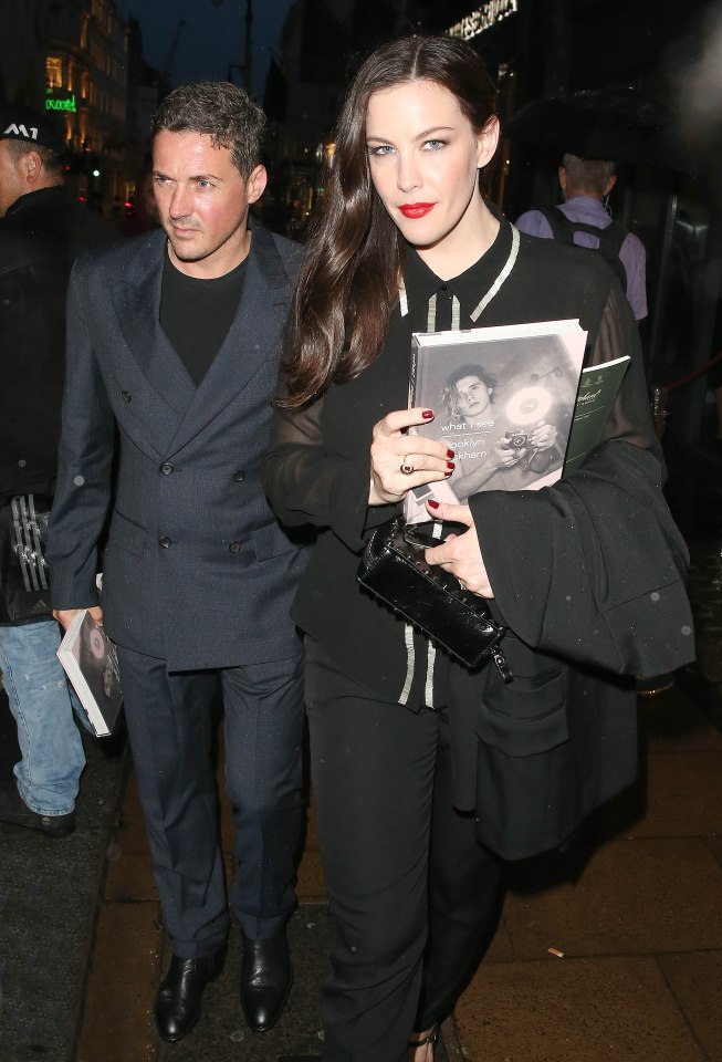 Dave Gardner and Liv Tyler, clutching a copy of Brooklyn's book