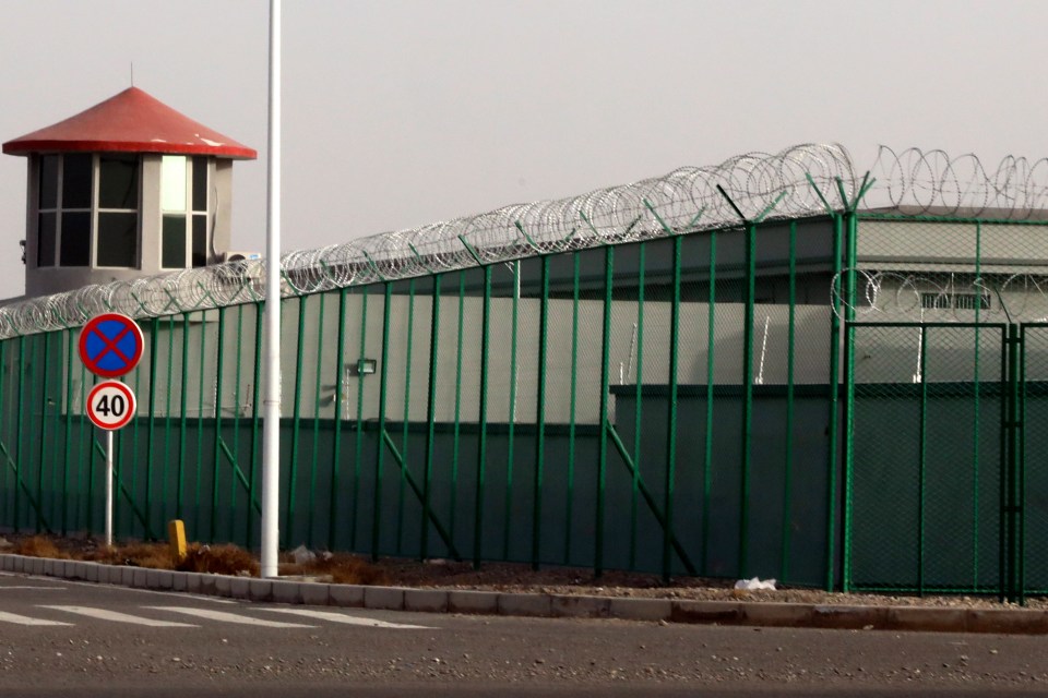 A guard tower and barbed wire fences surround one of the so-called 'centres'