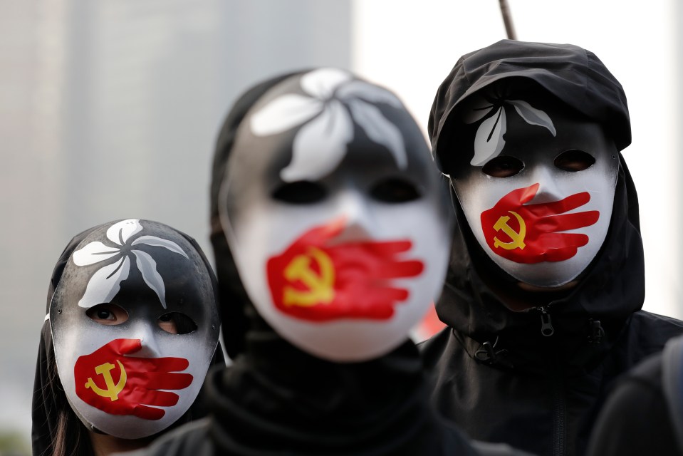 People wear masks during a rally to show support for Uighurs in Hong Kong