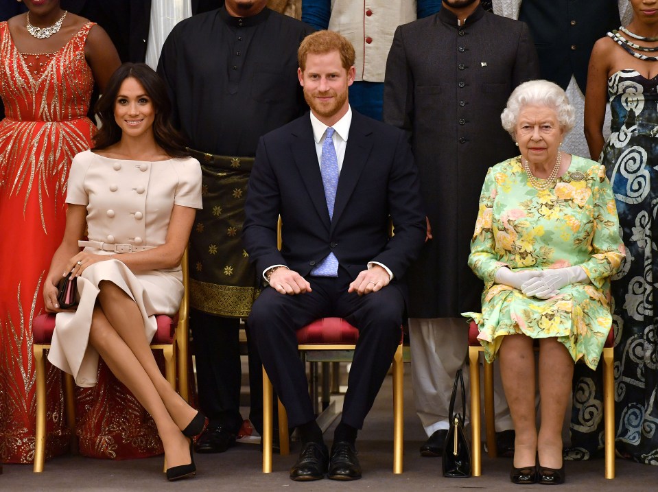 Meghan, Prince Harry and the Queen posing in happier times for the Royal Family