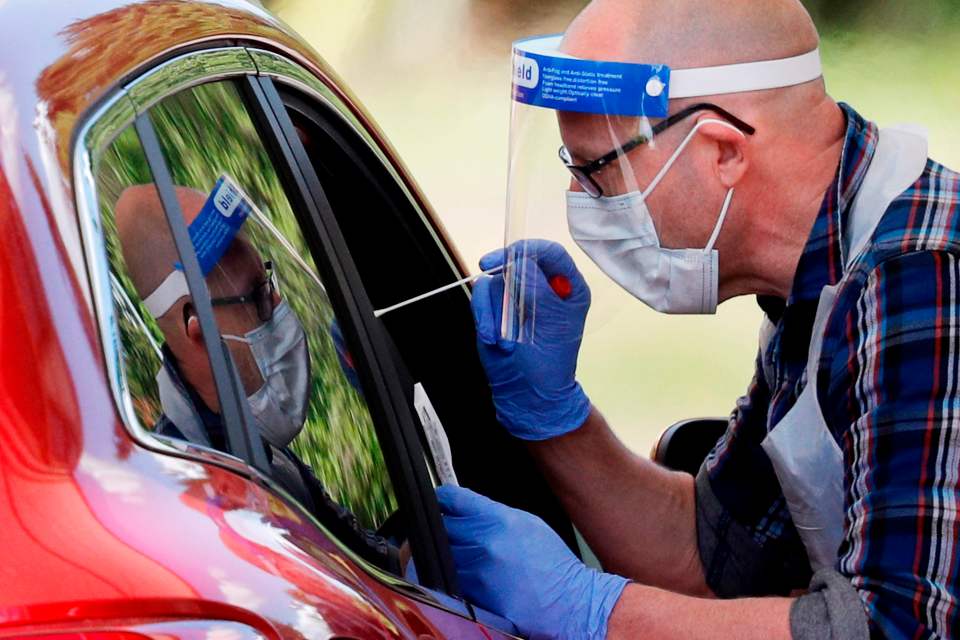 A medical worker takes a swab for coronavirus in England