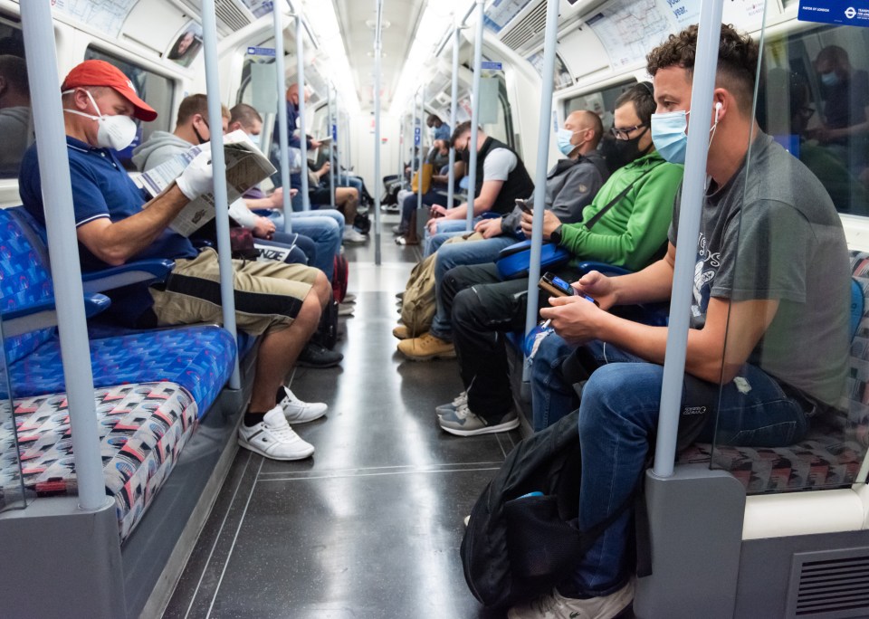 Commuters wear face masks as they travel on the London Underground