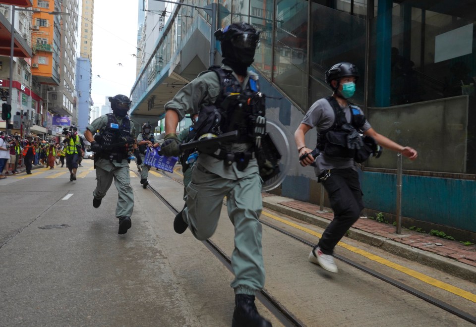 Riot police charge protesters