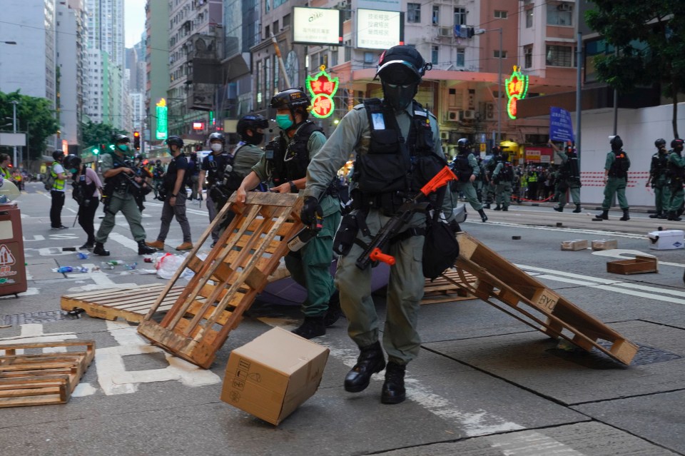 Police remove a roadblock set up by the protesters