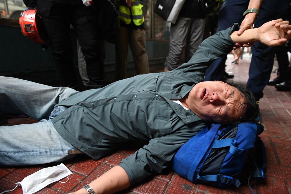 A protester lays on the ground during a rally against a new national security law