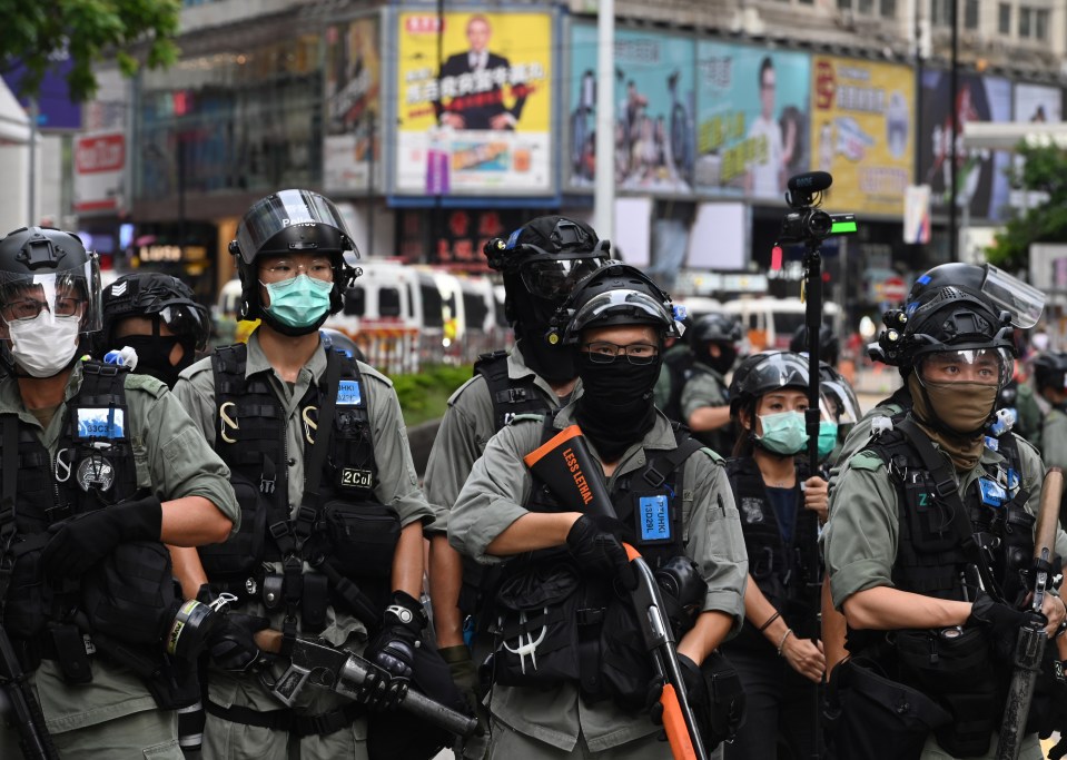 Riot police guard a road during a rally against a new national security law