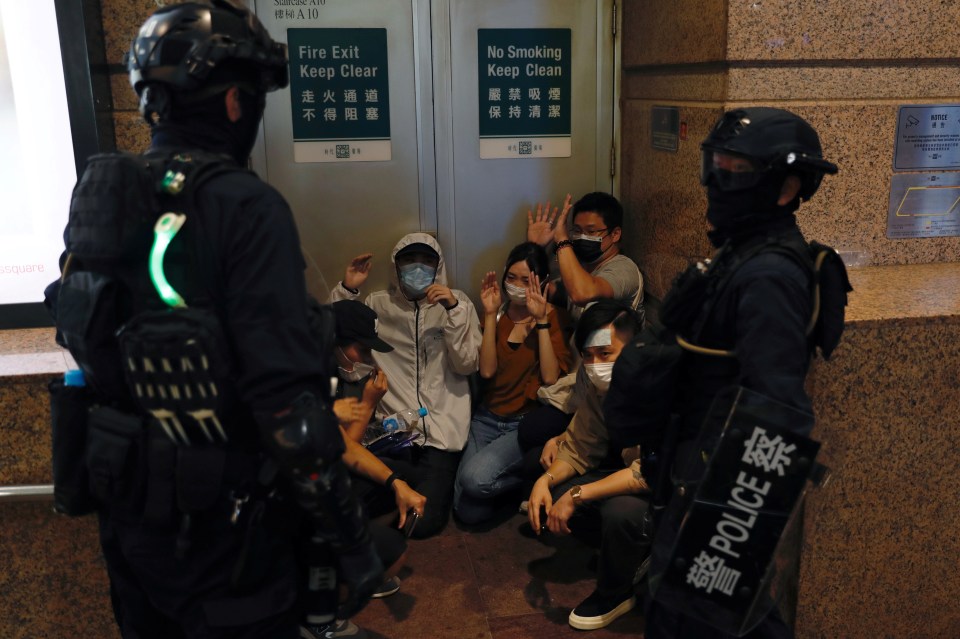 People are cornered in a fire exit by riot police during July 1 protests