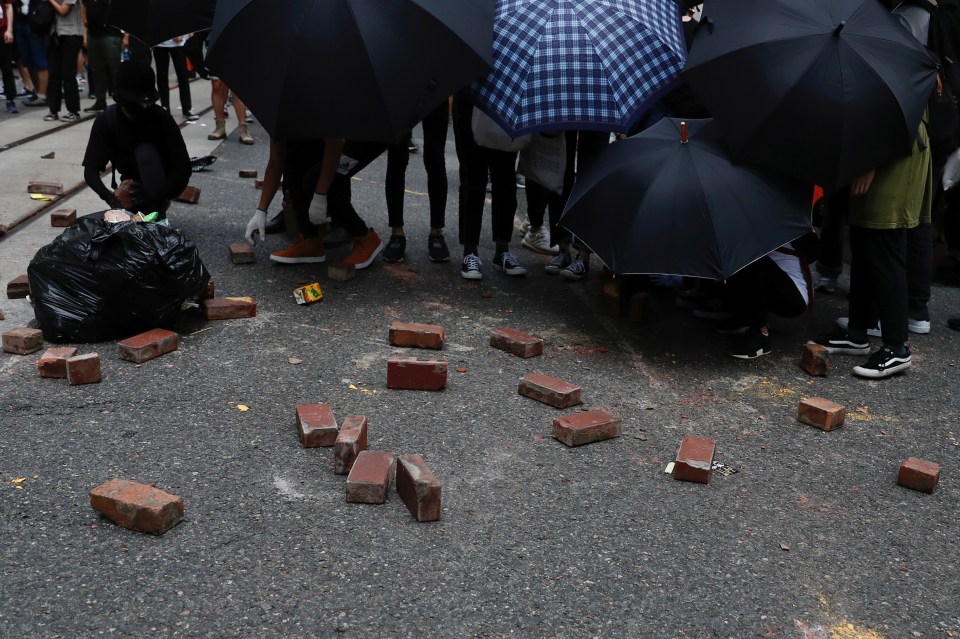 Anti-national security law protesters place bricks on road as a roadblock during a march