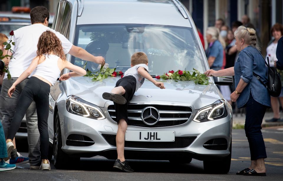 People laid roses on a hearse carrying Xander at his funeral today