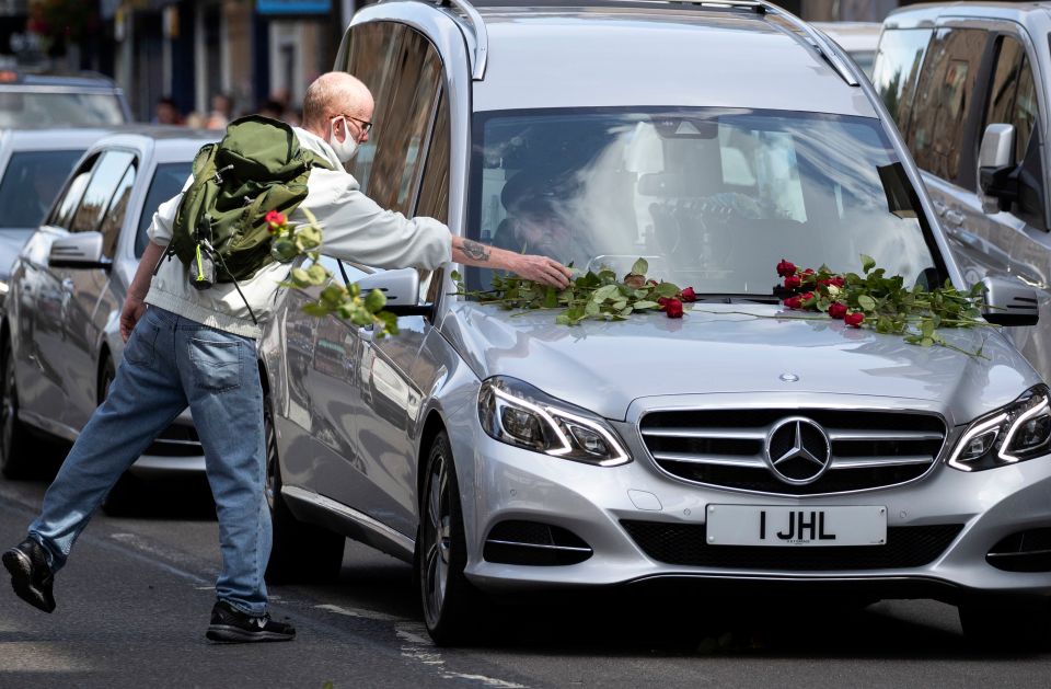 Hundreds of red roses were placed on the hearse 