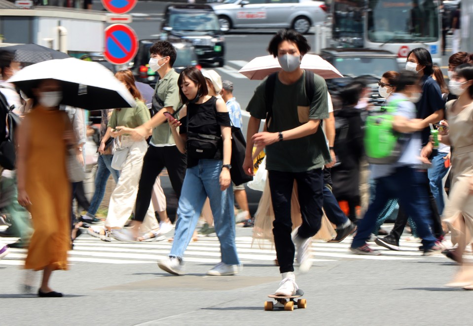 People walk on the Shibuya crossing in Tokyo, Japan on July 12