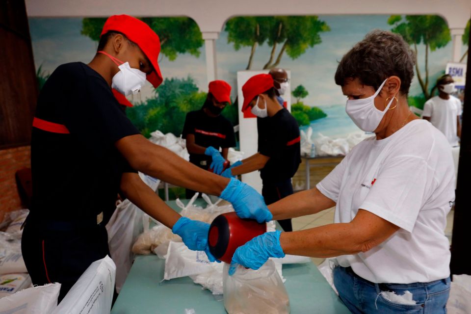 Volunteers and workers prepare food packages for Cayenne