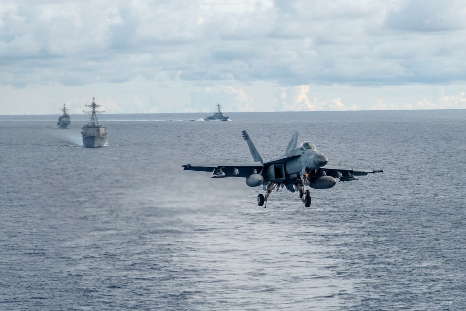 An F/A-18E Super Hornet flies with the strike group