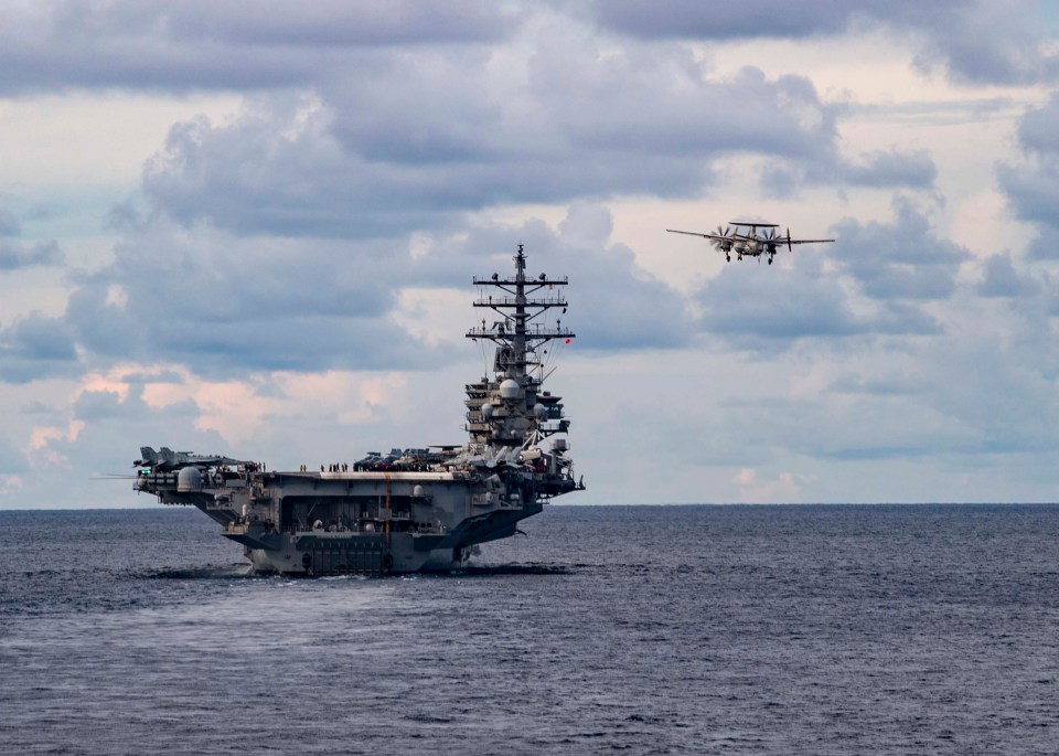 An E-2D Advanced Hawkeye flies alongside USS Ronald Reagan