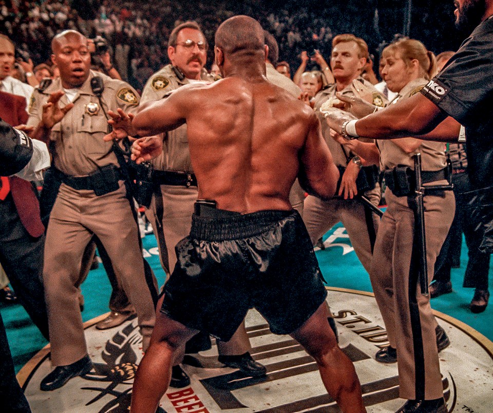 Police officers tried to restrain Tyson after the boxer bit off part of Holyfield's ear in Las Vegas in 1997