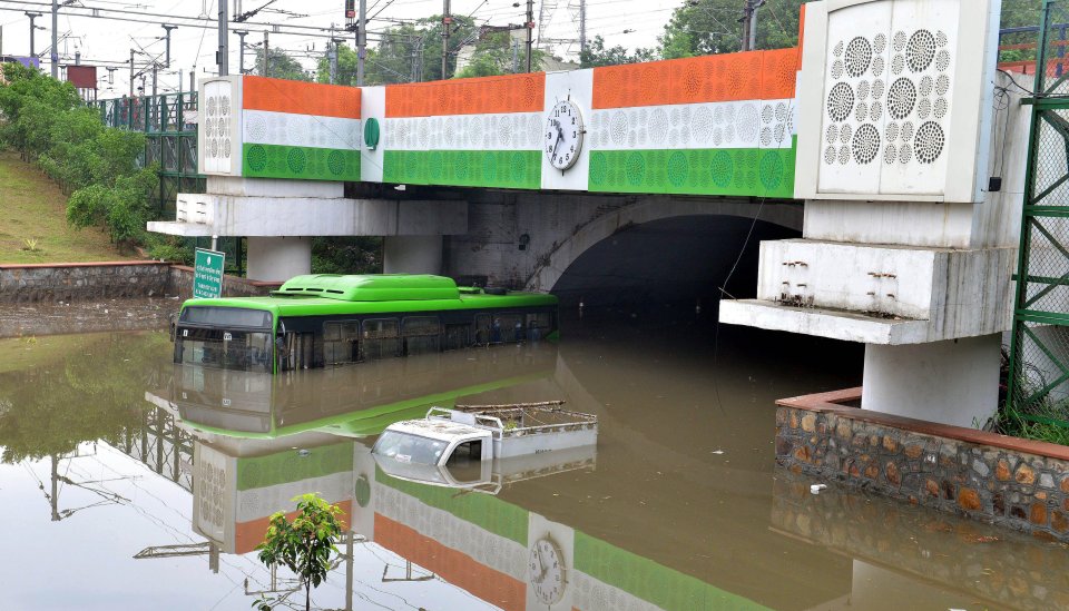 A passenger bus and a van are seen submerged in flood following a heavy downpour in New Delhi, India, on July 19