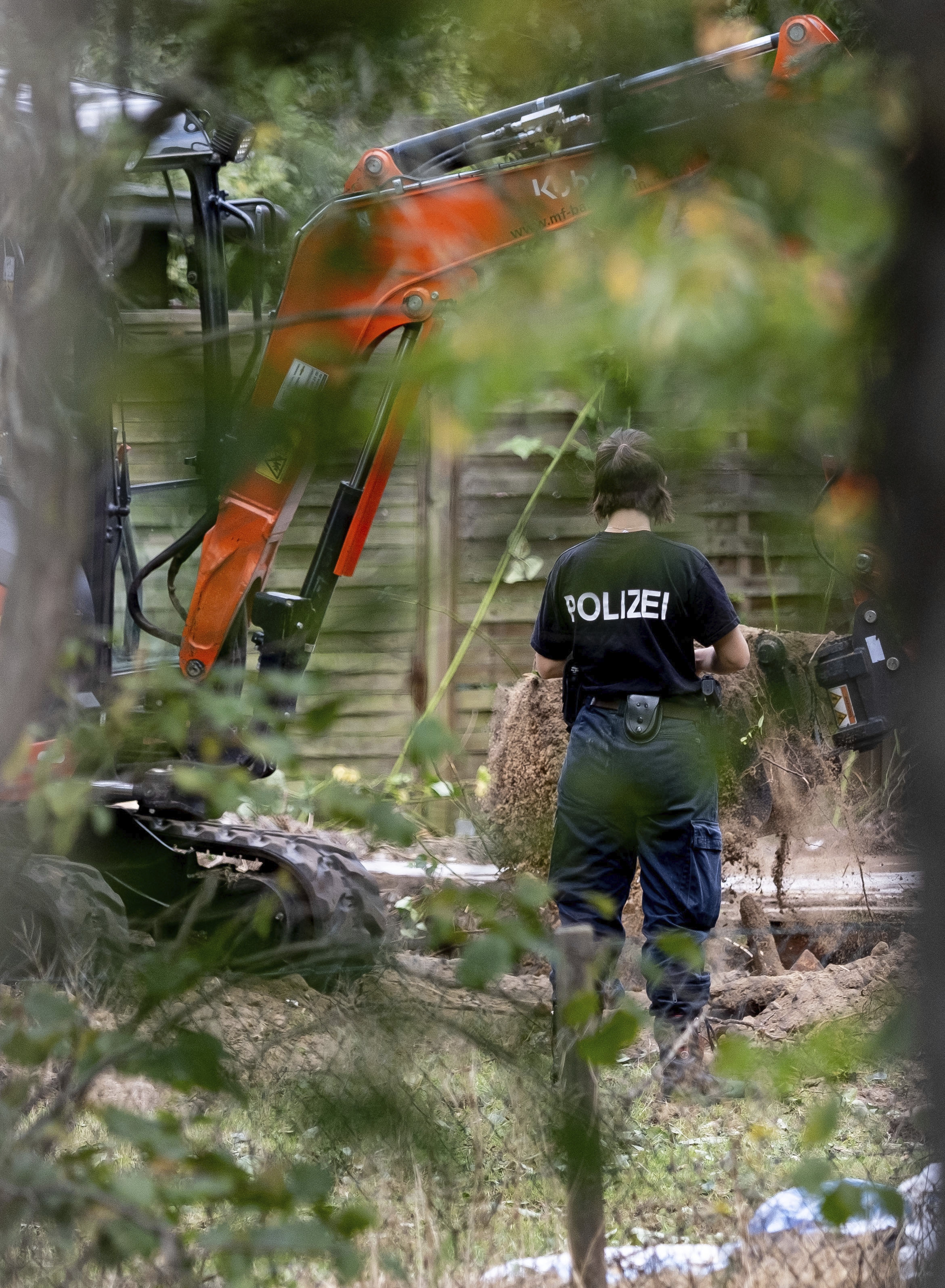 Officers using a digger search the allotment garden plot in Seelze, near Hanover