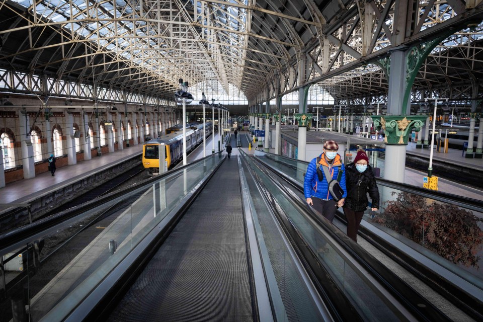 Two people wearing masks in Manchester’s Piccadilly station