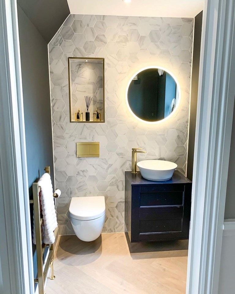  The downstairs toilet follows a modern vibe with a marble tiled wall