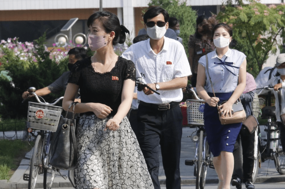 People wearing masks walk in the Ryomyong street in Pyongyang, North Korea Friday, July 3