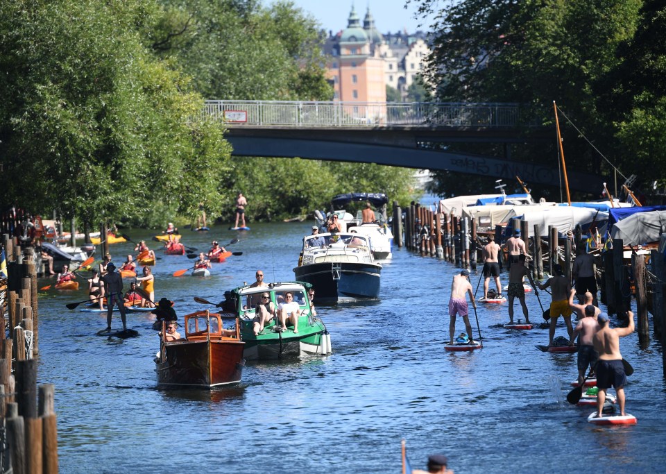 People enjoy boat rides, canoe paddling and stand up paddle at the Palsund canal in Stockholm, Sweden