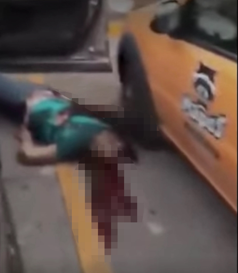 A bloodied body lies beside a bullet strewn car after an apparent shooting