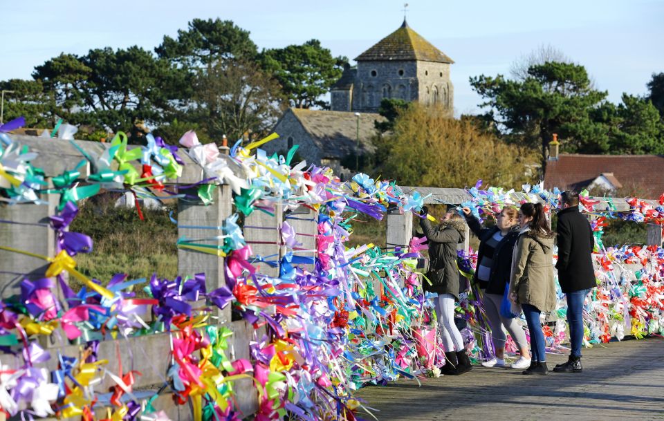 People place floral tributes on the Old Tollbridge near the A27 at Shoreham in West Sussex